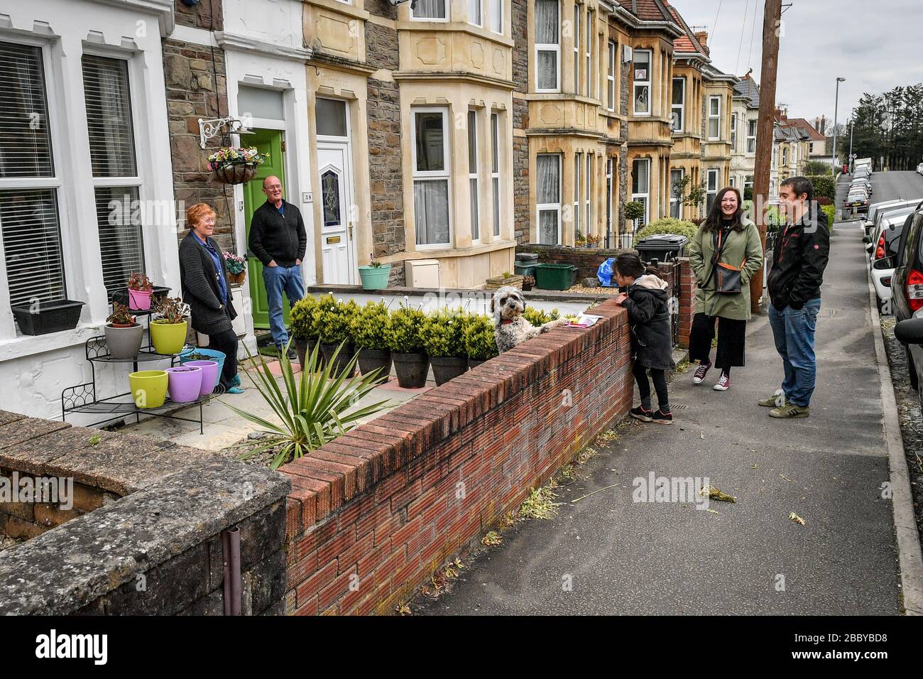 Una famiglia pratica sicuro distanziando come visitano i parenti per lasciare una carta di compleanno a Brislington, Bristol come il Regno Unito continua nel blocco per contribuire a frenare la diffusione del coronavirus. Foto Stock