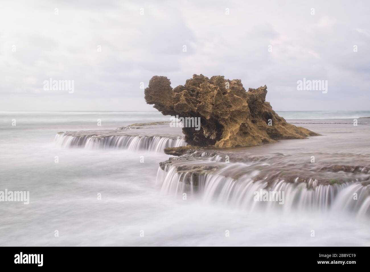 Un desaturato Dragon's Head Rock a Rye, con acqua setosa e liscia che scende dalle rocce circostanti Foto Stock