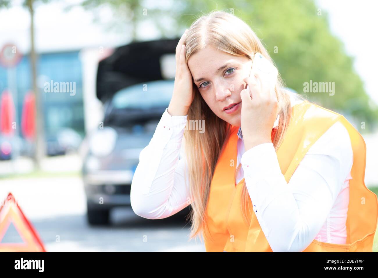 Una giovane donna si rompe con la sua auto Foto Stock