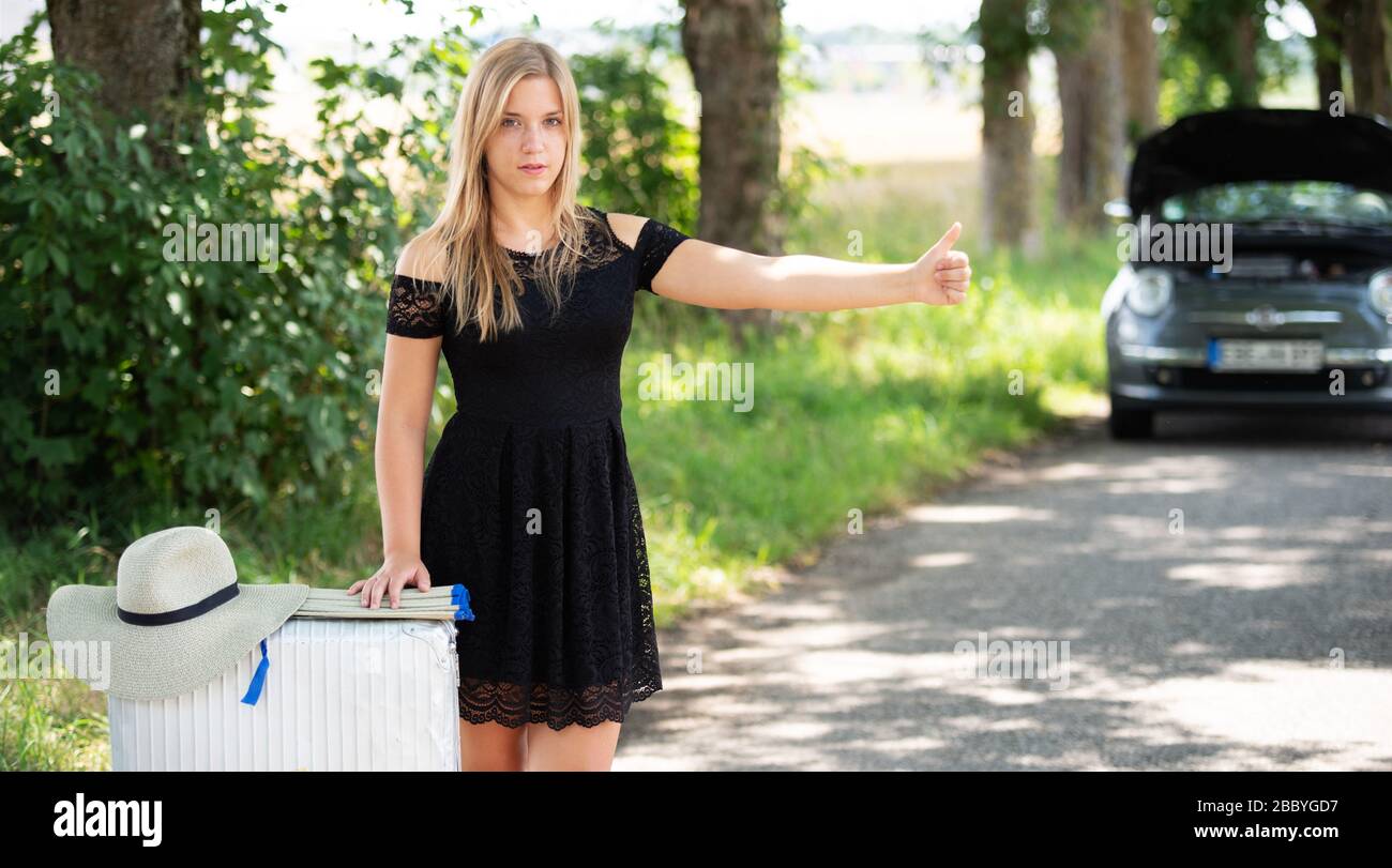 Una giovane donna si rompe con la sua auto Foto Stock