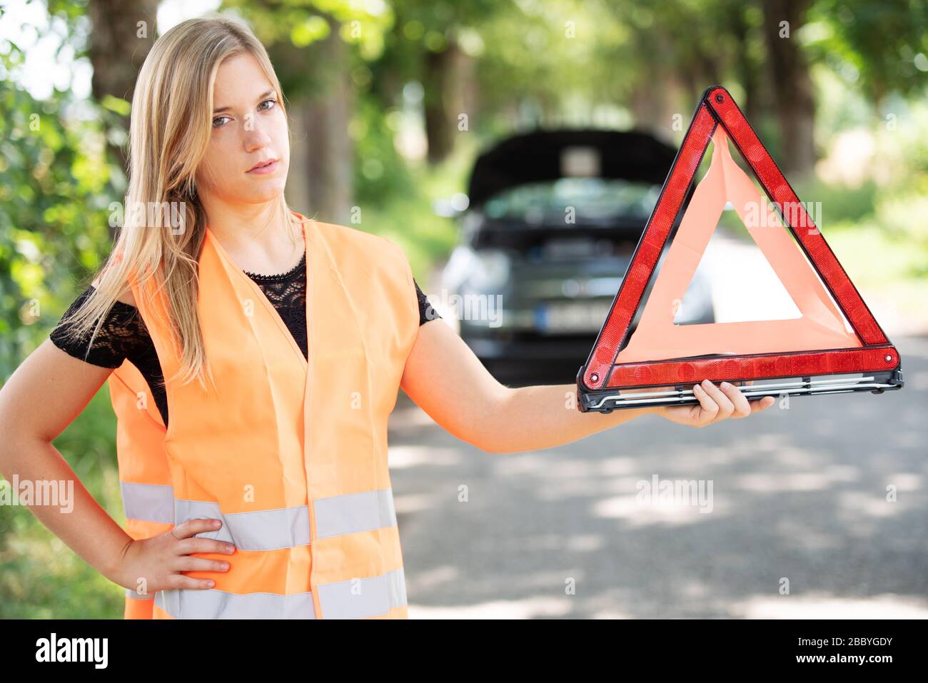 Una giovane donna si rompe con la sua auto Foto Stock