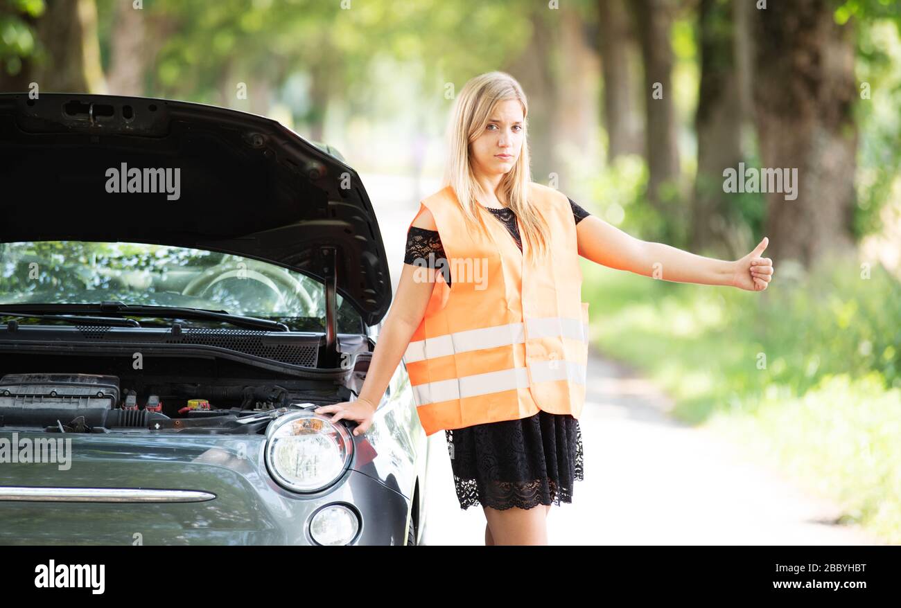 Una giovane donna si rompe con la sua auto Foto Stock