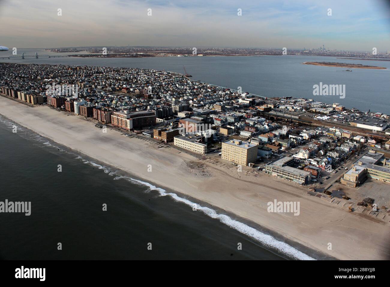 Qui potete vedere un po' dei danni lungo la spiaggia con lo skyline di Manhattan sullo sfondo. Foto Stock