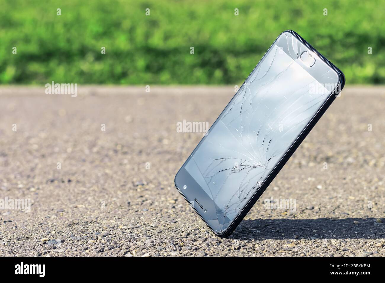 Lo smartphone nero moderno cade sull'asfalto all'angolo dello schermo. Un  telefono cellulare con uno schermo rotto, rotto, rotto e incrinato con  spazio di copia Foto stock - Alamy