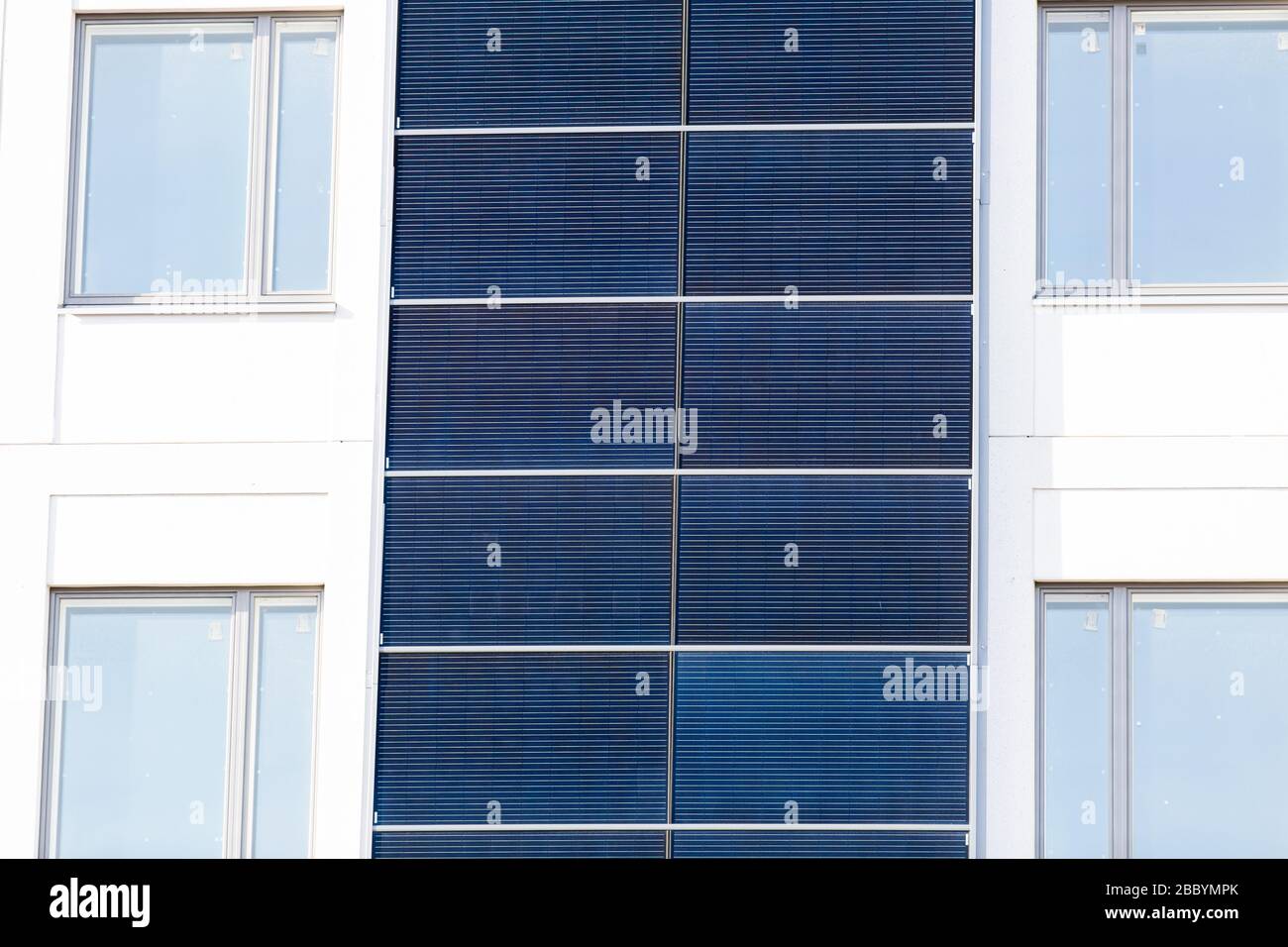 Edificio bianco con pannelli solari installati sulle pareti esterne. Foto Stock