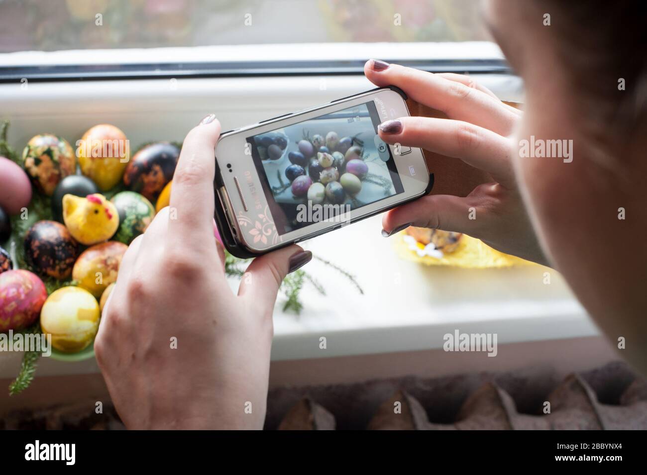 Una ragazza fotografa la sua casa ha fatto le uova di Pasqua usando un cameraphone mobile. Foto Stock