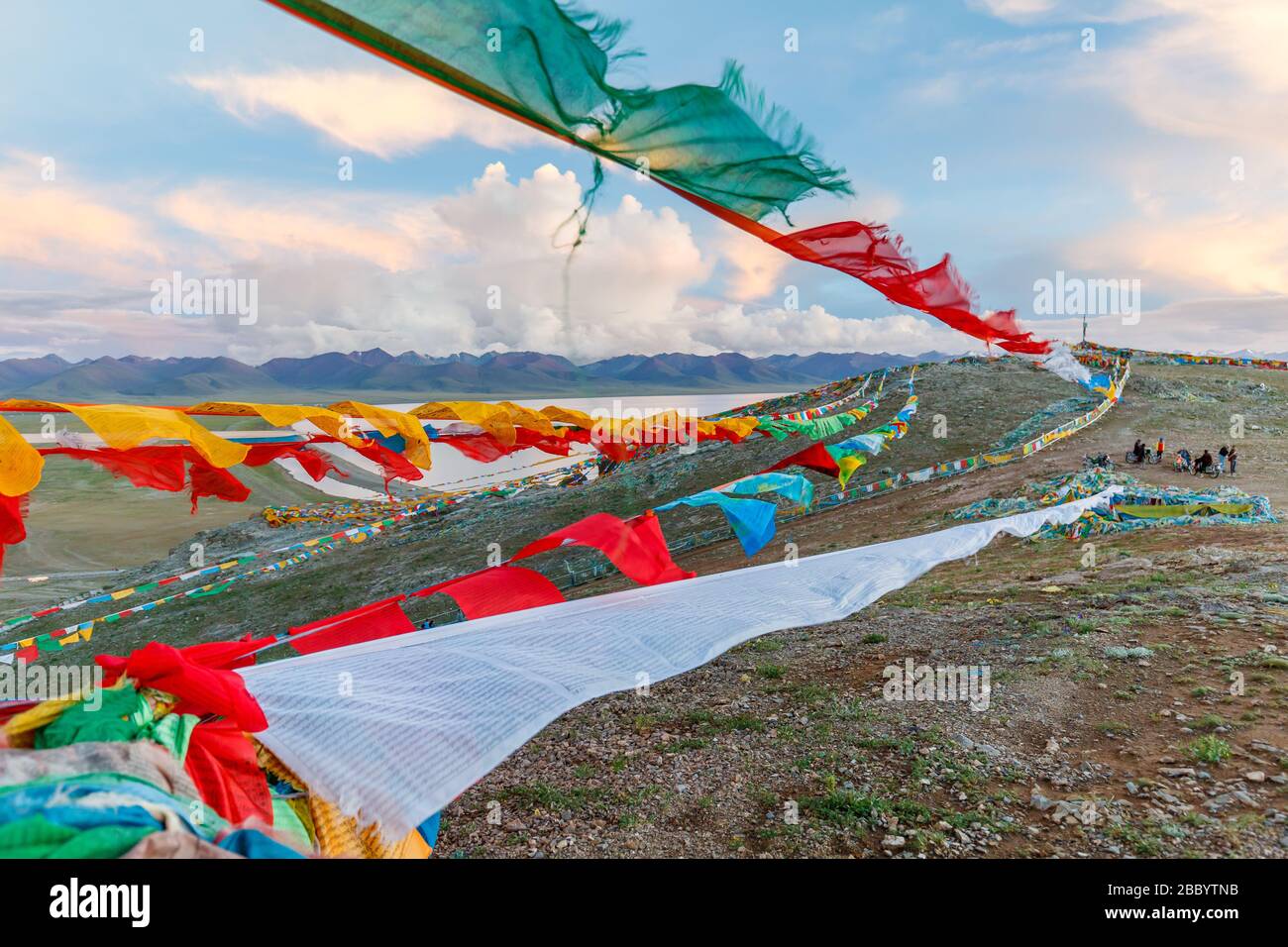 Bandiere di preghiera colorate sulle corde - volare / ondeggiando nel vento. I tibetani credono che le preghiere e i mantra saranno soffiati dal vento per diffondere il bene Foto Stock