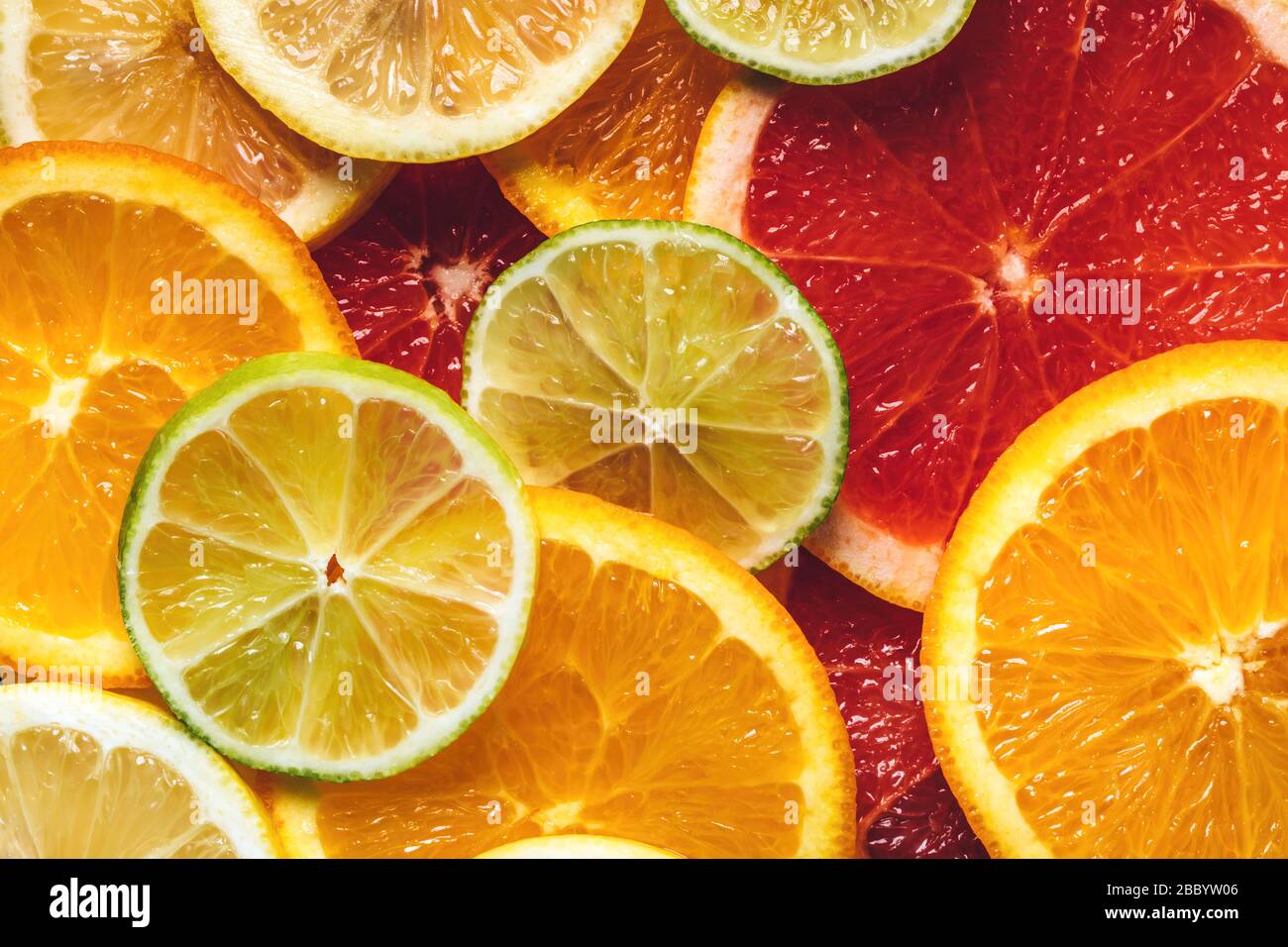 Motivo Flatlay di agrumi arancio, limone, lime e pompelmo fette di fondo. Vista dall'alto. Design minimo. Foto Stock