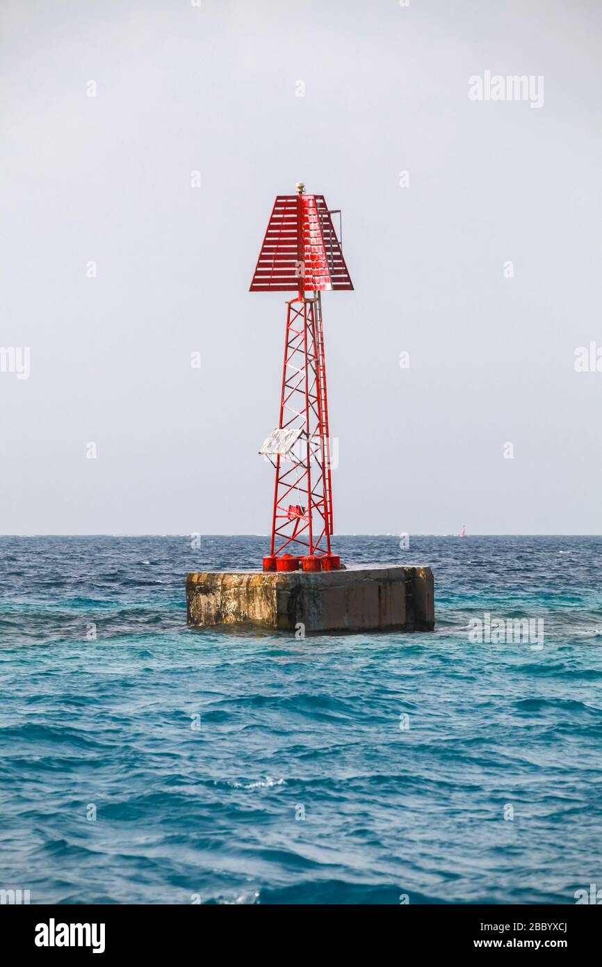 Il faro rosso con il simbolo del triangolo si trova nell'acqua del Golfo Persico, Arabia Saudita. Foto verticale ravvicinata Foto Stock