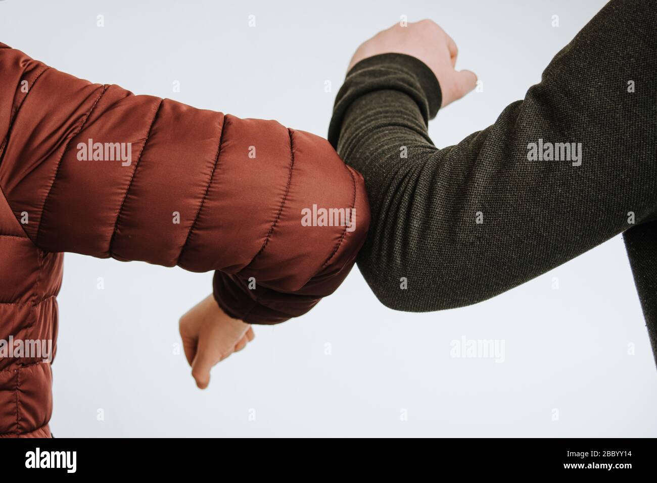 Urto del gomito. Saluto per evitare la diffusione del coronavirus. Amici di donna e uomo si incontrano. Corona covid-19 Foto Stock