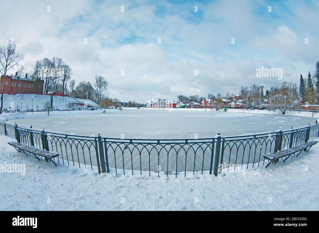 Giorno nevoso invernale in Russia - Stagno Kelarskiy in piccola città Sergiev Posad, cielo blu, acqua ghiacciata, fisheye, distorsione prospettiva, grandangolo. Foto Stock