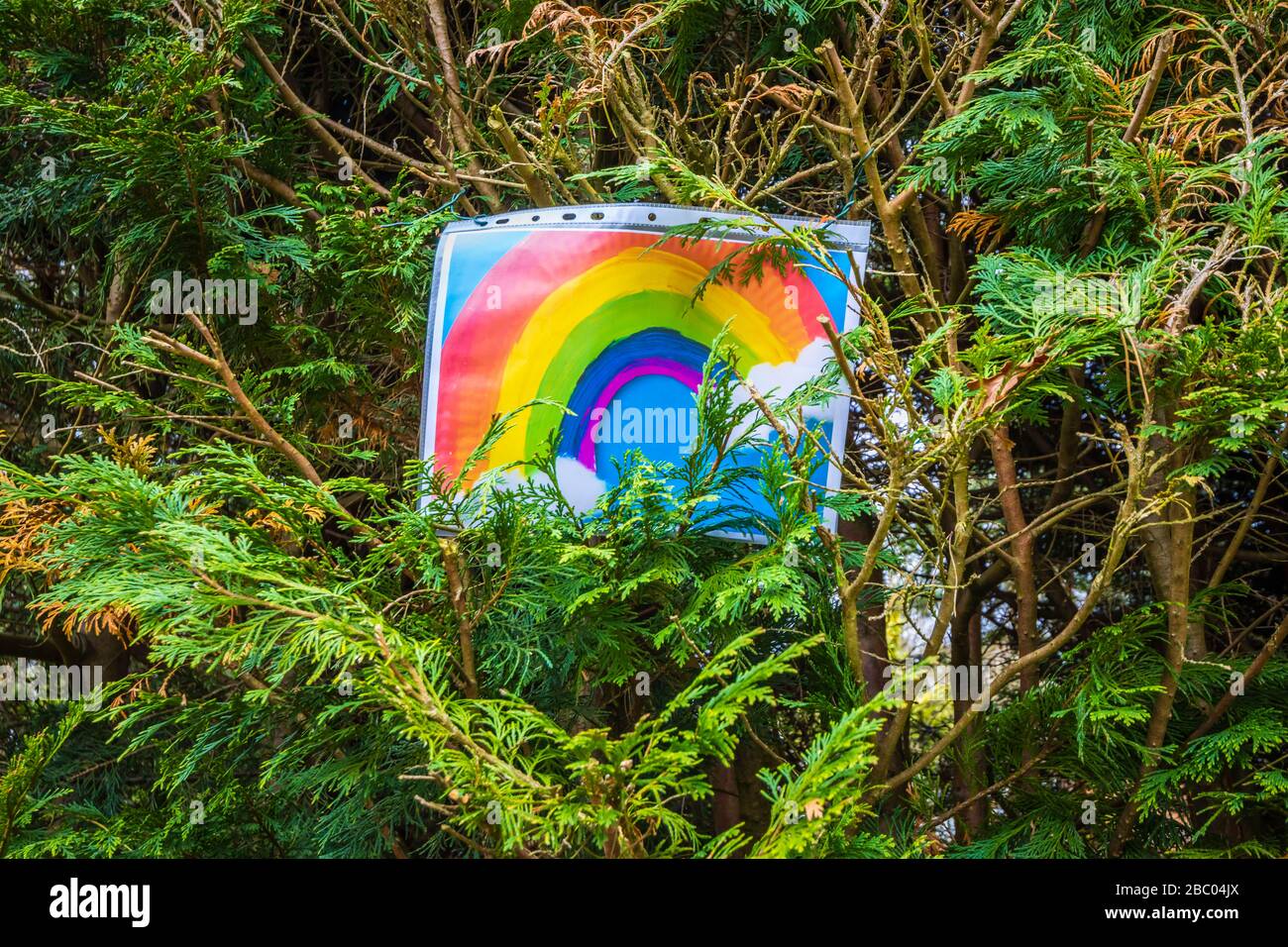 Immagine del bambino di un arcobaleno in una strada di Woking come la gente prova a rimanere isolata positiva nelle loro case durante la pandemia di coronavirus e la chiusura a chiave Foto Stock