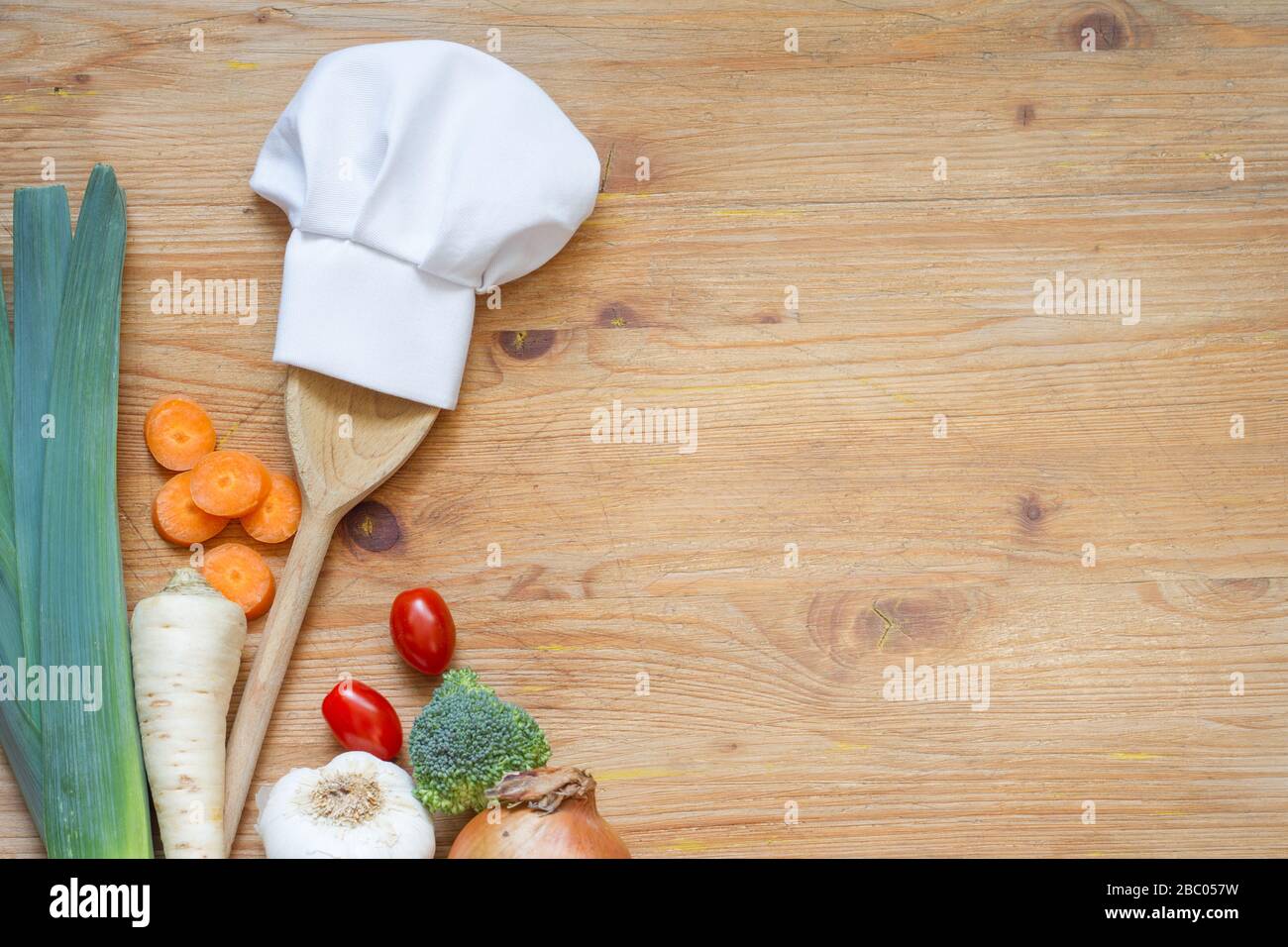 Cappello dello chef sul cucchiaio e verdure cucina cibo di fondo concetto Foto Stock