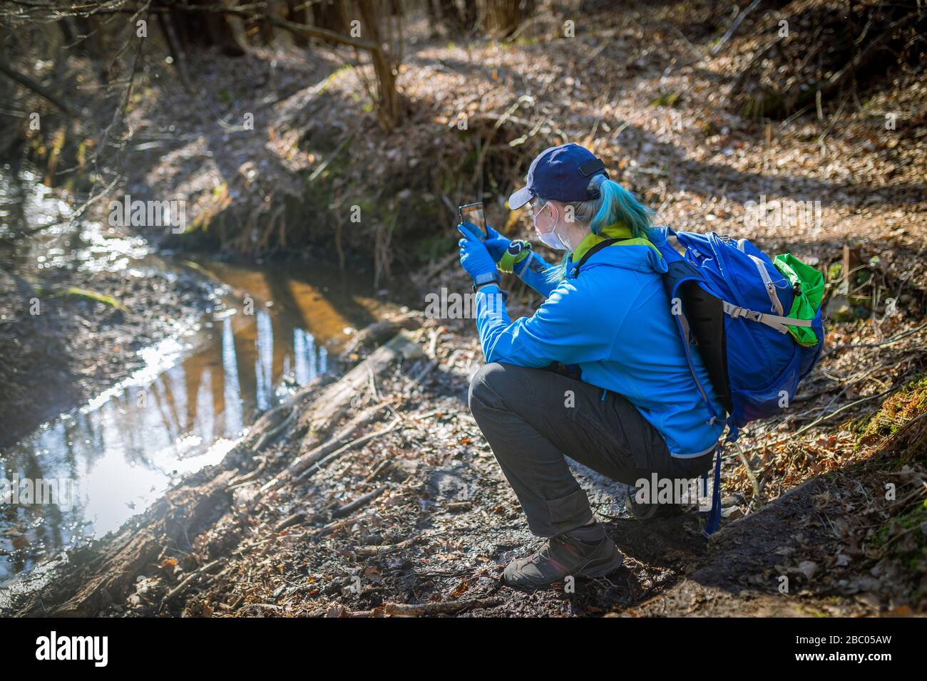donna che spara un fiume nella foresta per telefono Foto Stock