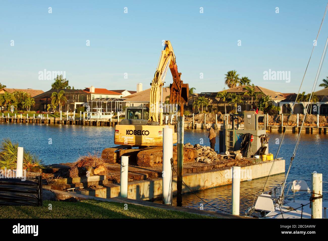 Sostituzione idrovwall, barca da lavoro, gru, occupazione, riparazione, nautica, acqua, luce dorata, business, Punta Gorda; FL Foto Stock