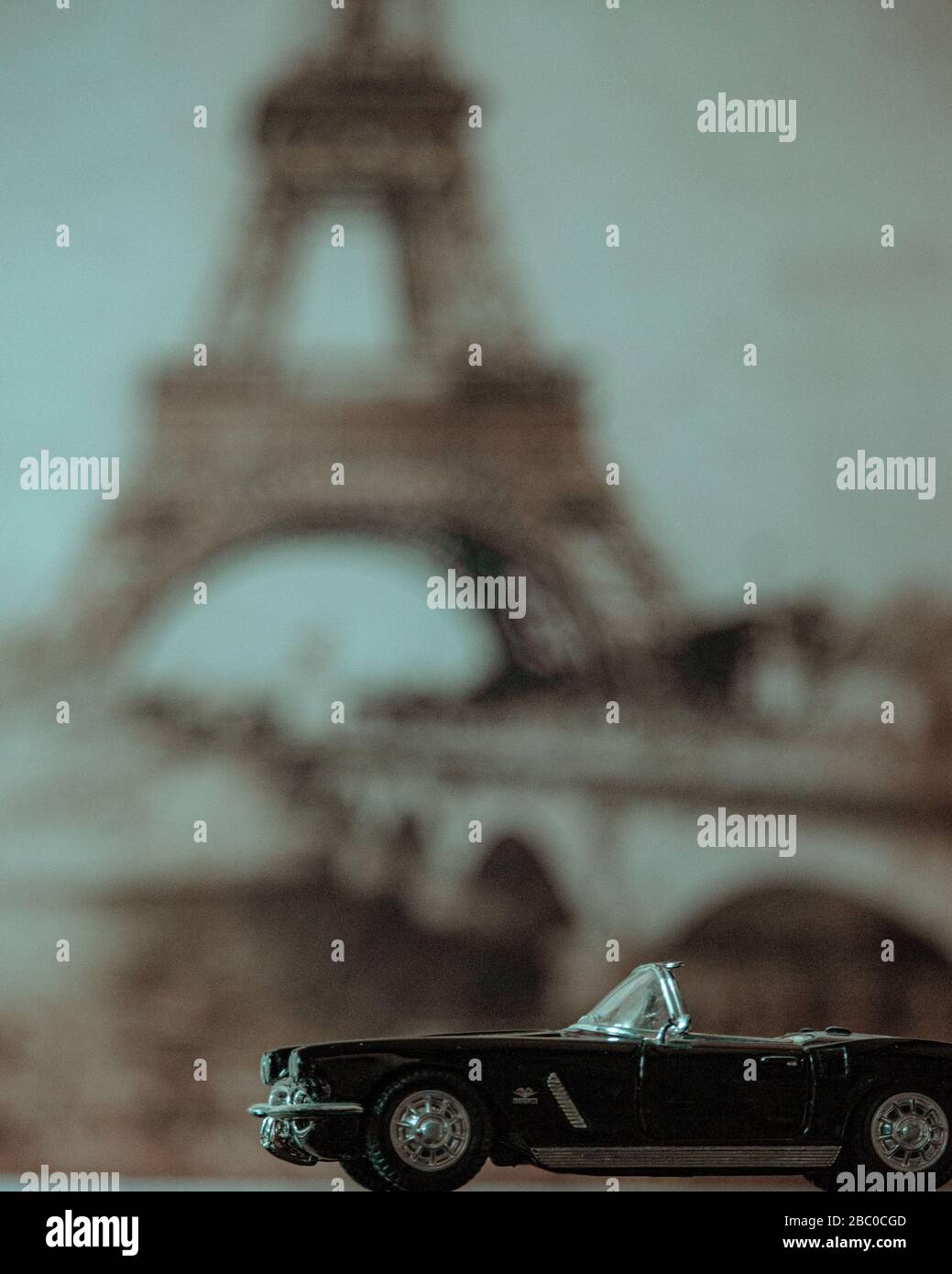 Un'auto modello con la Torre eiffel sullo sfondo. Angolo, vacanza, cabrio. Foto Stock