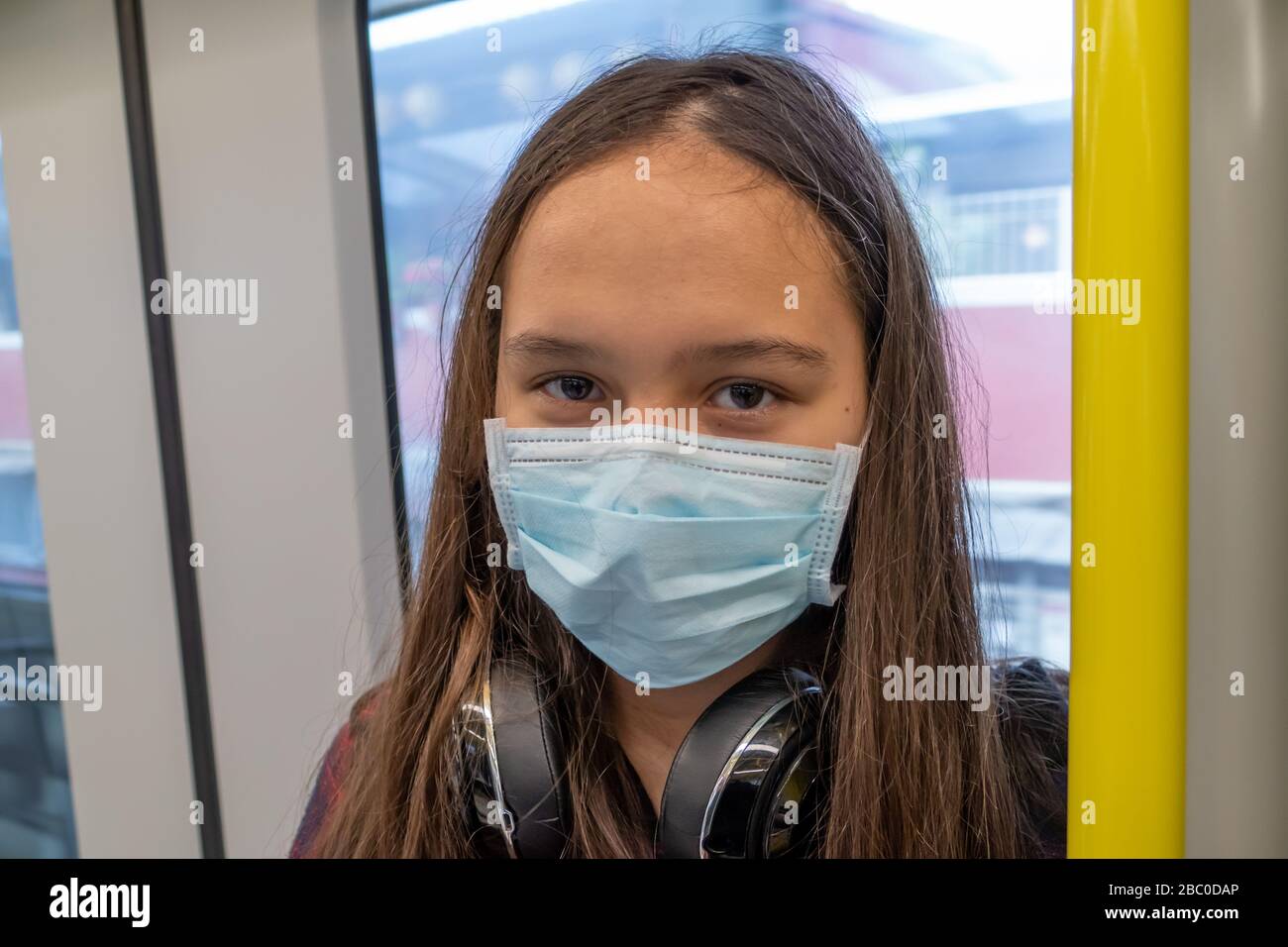 Giovane ragazza asiatica americana che indossa maschera chirurgica sulla metropolitana Foto Stock