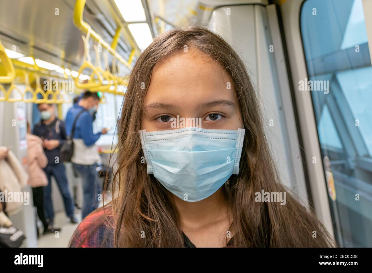 Giovane ragazza asiatica americana che indossa maschera chirurgica sulla metropolitana Foto Stock