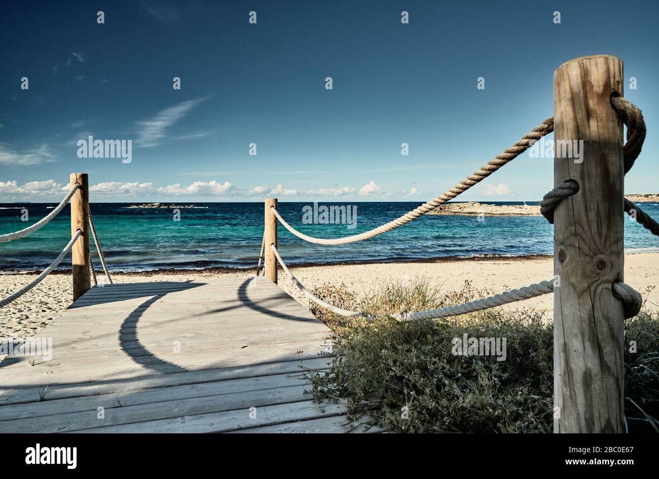 Il percorso verso una spiaggia di mare, un percorso consiste di tavole di legno, su ogni lato una recinzione da una corda di mare, acqua di colore azzurro, tempo libero Foto Stock