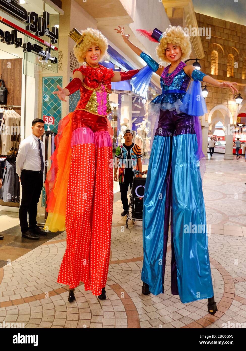 Donne promozionali su palafitte all'interno del centro commerciale Ibn Buttata, Dubai, Emirati Arabi Uniti. Ibn Battaglia era uno studioso musulmano, ed esploratore che viaggiava ampiamente nel mondo. Foto Stock