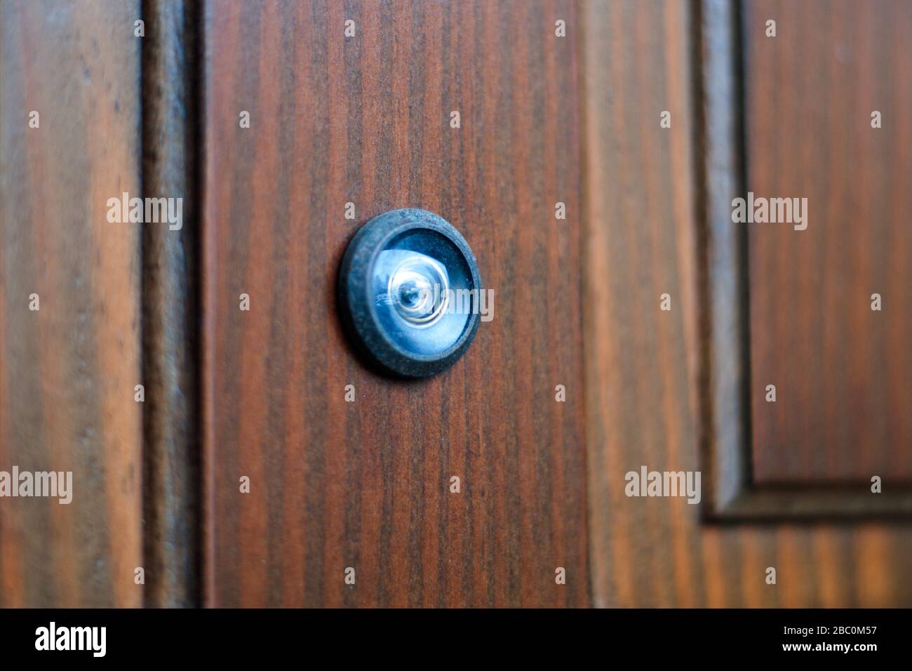 primo piano di un spioncino su una porta di legno Foto Stock
