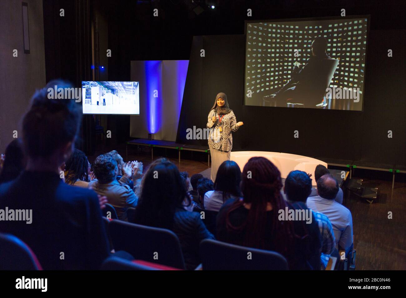Altoparlante femmina in hijab sul palco che parla con il pubblico della conferenza Foto Stock