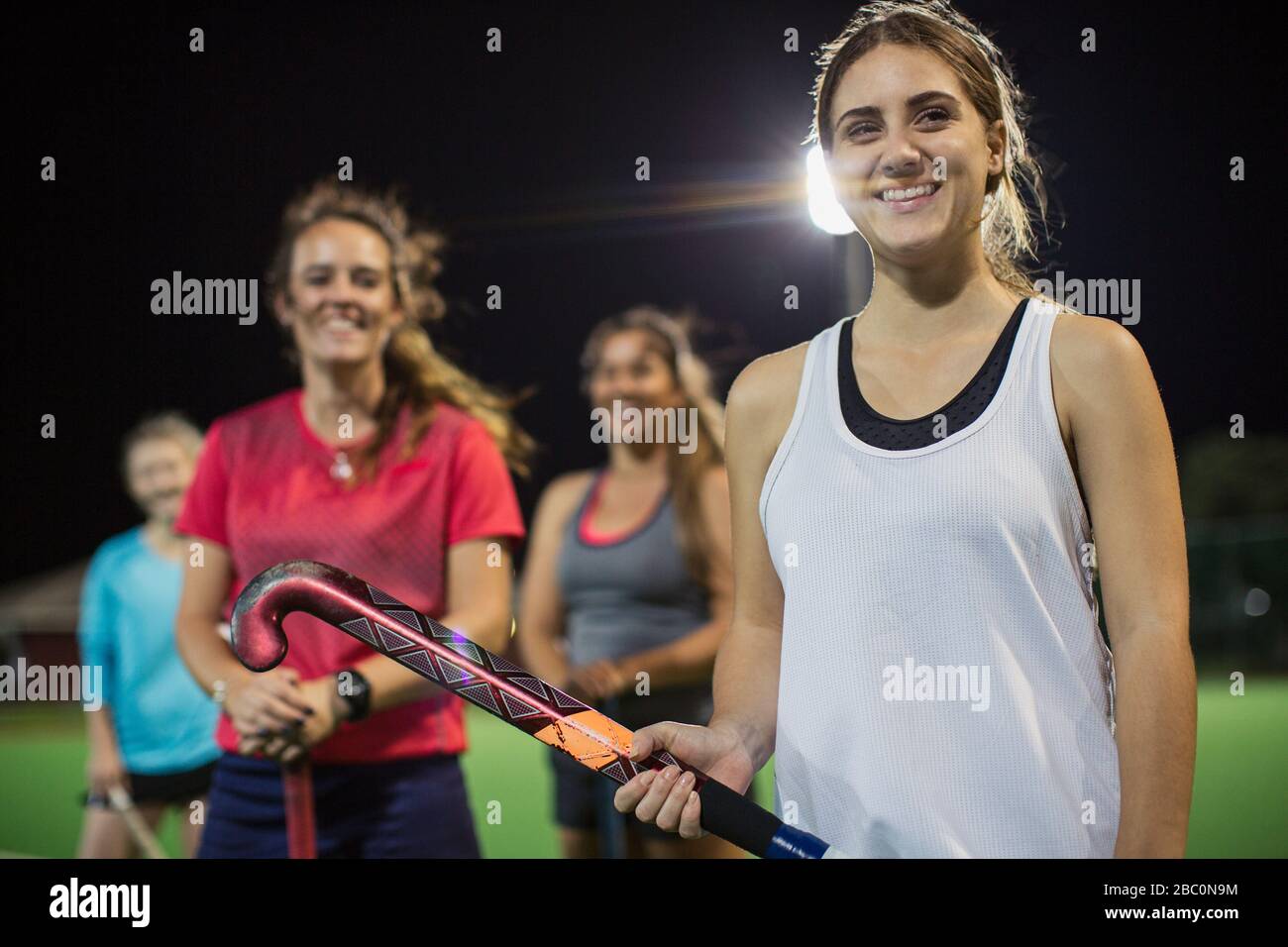 Ritratto sorridente, fiducioso giovani giocatori di hockey da campo femminile Foto Stock