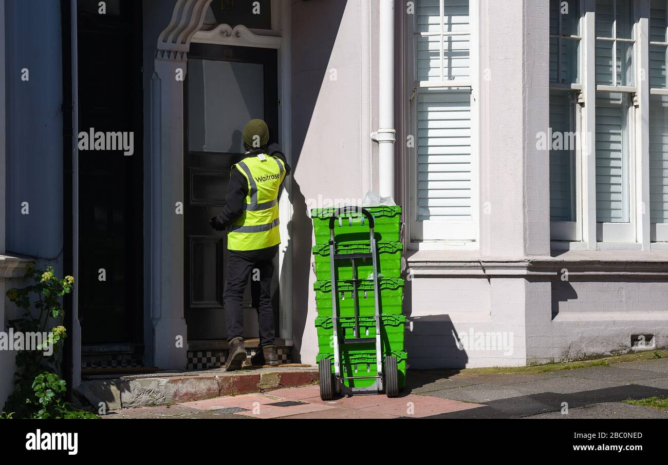 Waitrose online shopping delivery man waving a mask and van durante il coronavirus COVID-19 crisi Brighton UK Marzo 2020 Foto Stock