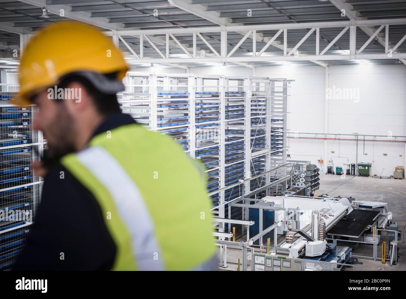 Supervisore maschile che parla, utilizzando walkie-talkie sulla piattaforma in fabbrica Foto Stock