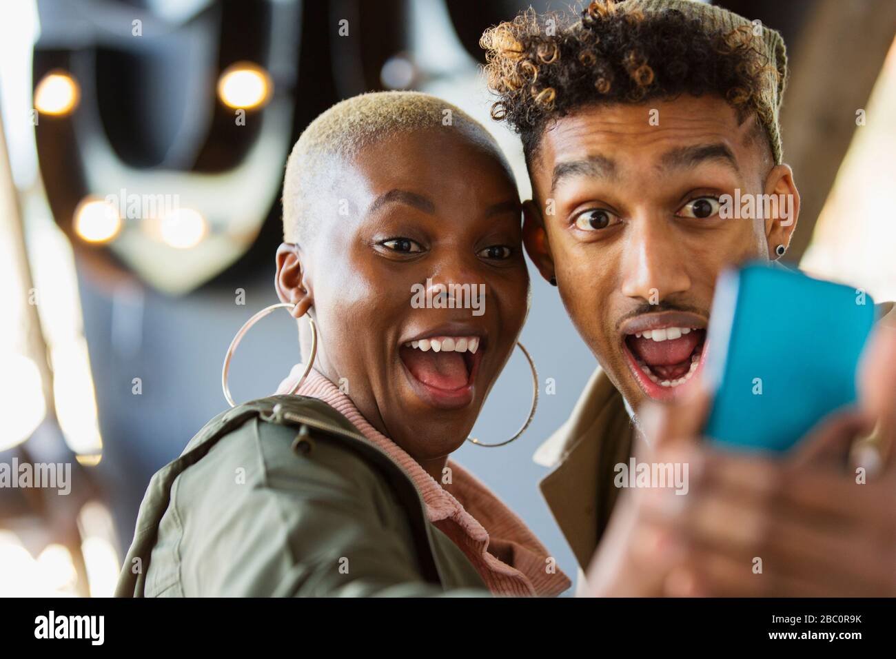 Giovane coppia giocosa che prende selfie con il telefono della macchina fotografica Foto Stock