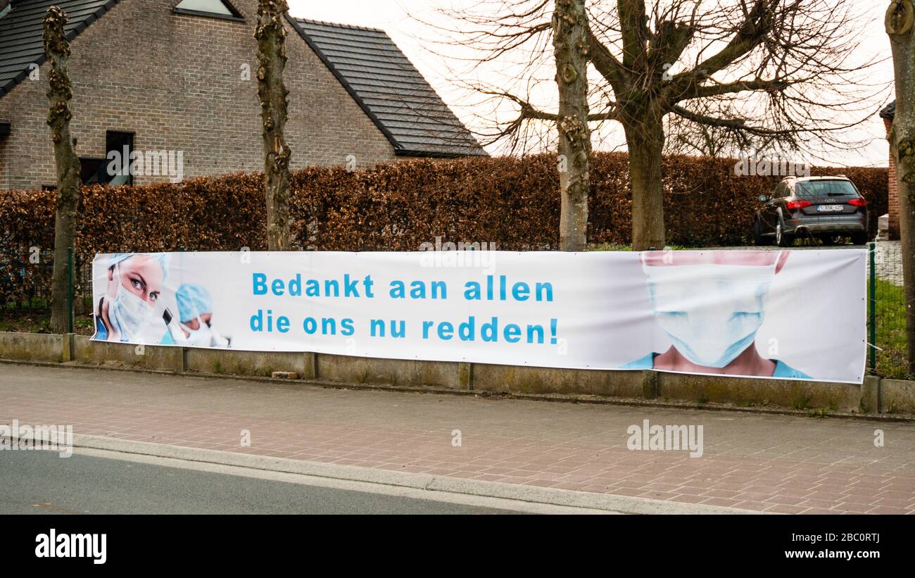 Aigem, Belgio, 29th Mar 2020: Banner con immagine del personale medico e grazie nota a tutti coloro che ci salvano ora durante la crisi corona. Zona rurale. In olandese : Bedankt aan allen die ons nu redden. Foto Stock