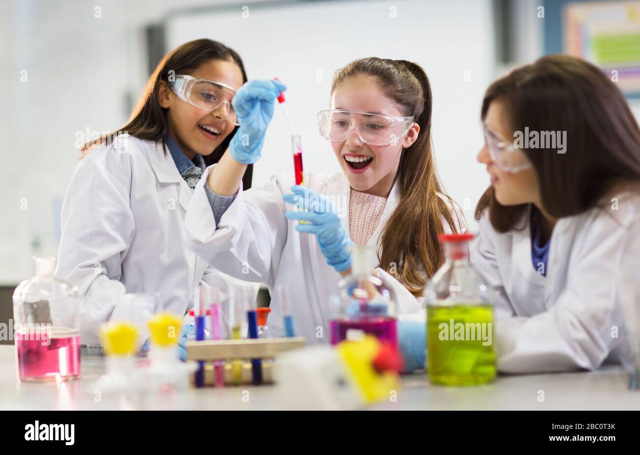 Studentesse curiose che conducono esperimenti scientifici in classe di laboratorio Foto Stock