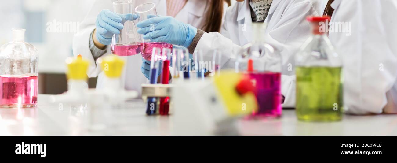 Liquido in flaconi, provette e becher in classe di laboratorio scientifico Foto Stock