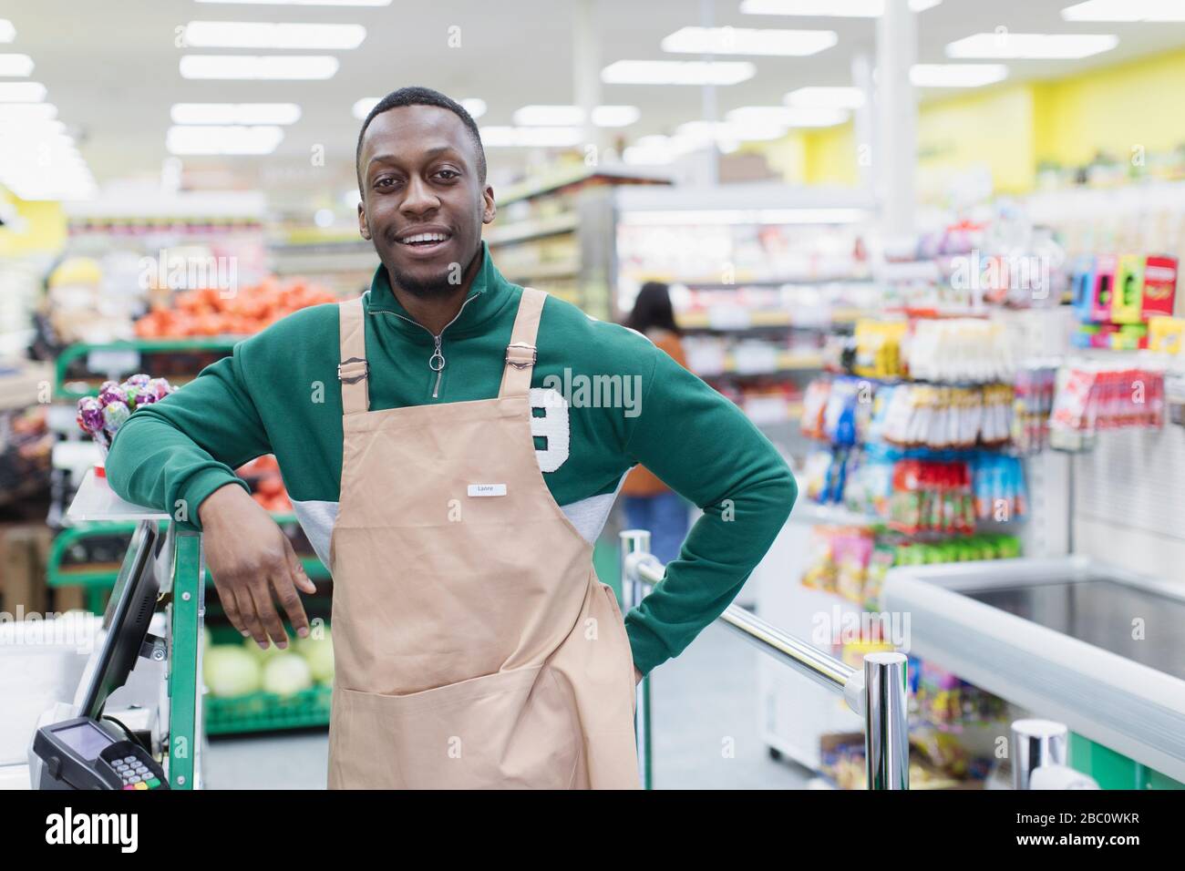 Ritratto sicuro drogheria maschile che lavora in supermercato Foto Stock