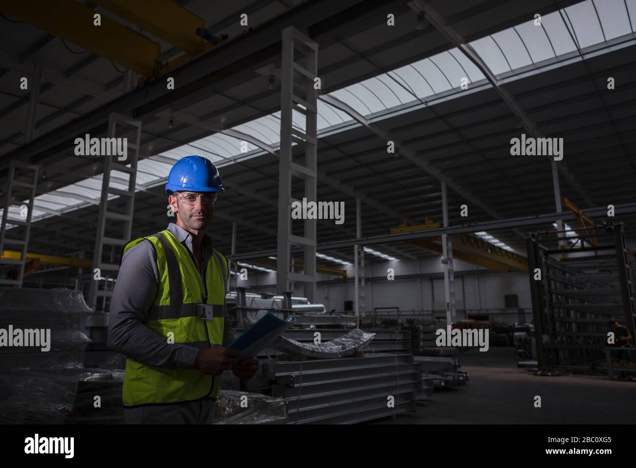 Ritratto serio, sicuro lavoratore maschile in fabbrica di acciaio scuro Foto Stock