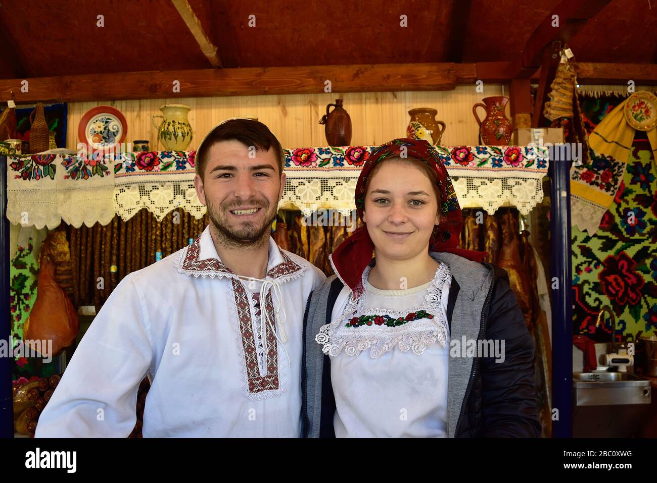 Romania, Timis, Timisoara, Maramures stalla alimentare e tradizionalmente vestita coppia, mercato di primavera, Piata Victoriei, città vecchia. Foto Stock