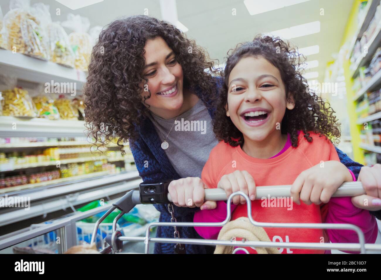 Ritratto felice madre e figlia shopping in supermercato Foto Stock