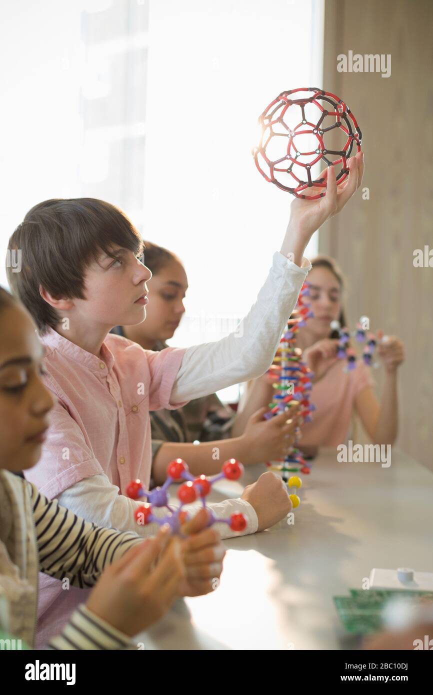 Studente ragazzo concentrato che esamina la struttura molecolare in classe di laboratorio Foto Stock