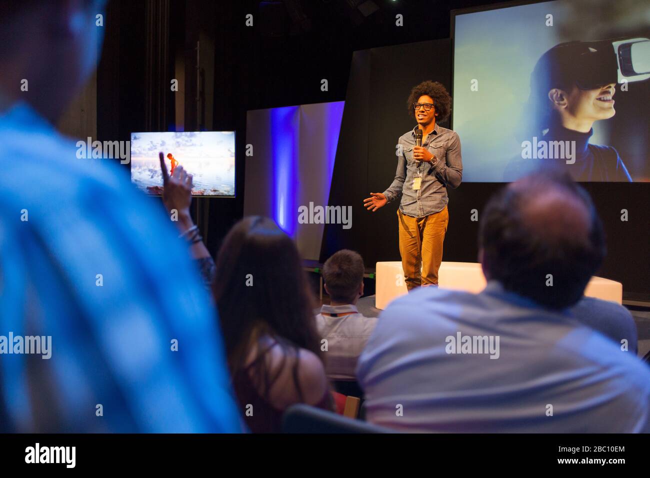 Altoparlante maschio sul palco che parla con il pubblico Foto Stock