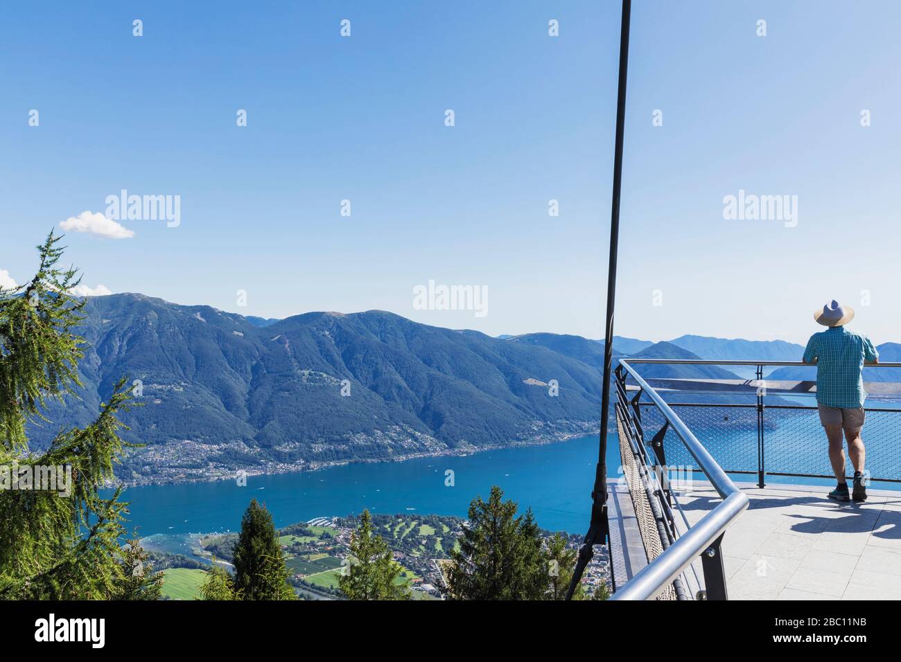 Escursionista in piedi sulla piattaforma panoramica Cardada sopra Locarno guardando verso Lago maggiore, Ticino, Svizzera Foto Stock