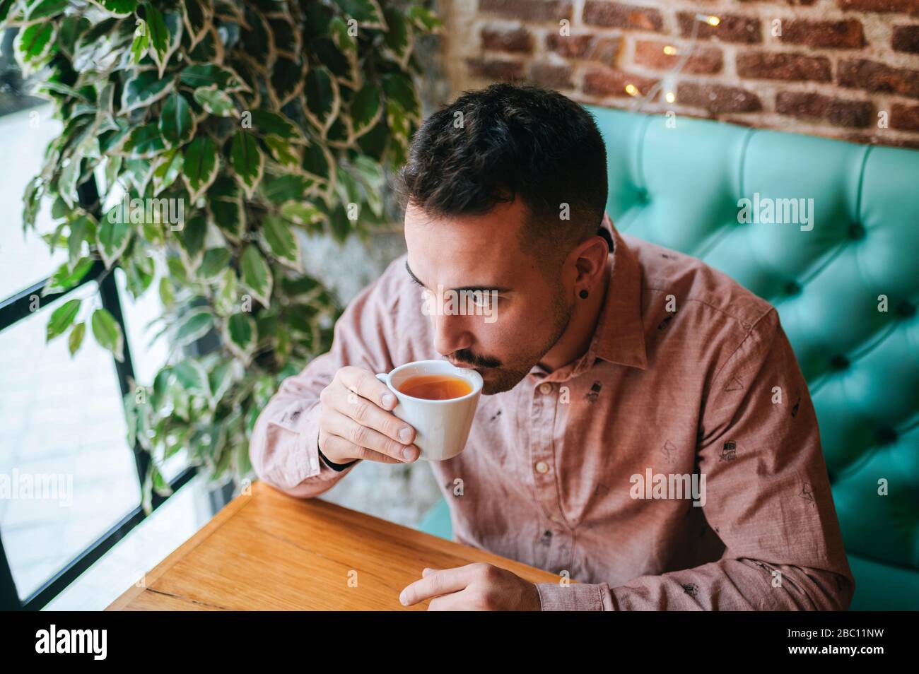 Uomo in un caffè bere una tazza di tè Foto Stock