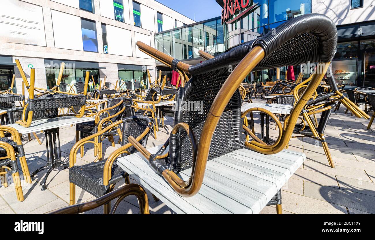 Caffetteria all'aperto. Tavoli vuoti nel ristorante. Effetto coronavirus. Una città deserta in Germania. Primavera in città. Sole e cielo. Foto Stock