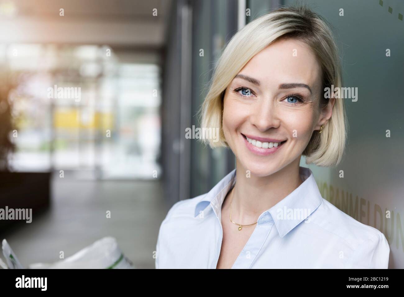 Ritratto di donna d'affari sorridente con occhi blu Foto Stock