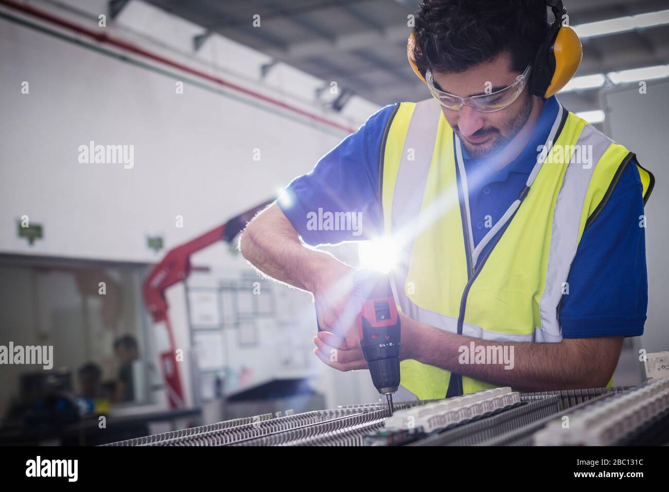 Ingegnere maschio con attrezzatura di assemblaggio per perforatrici elettriche in fabbrica di acciaio Foto Stock