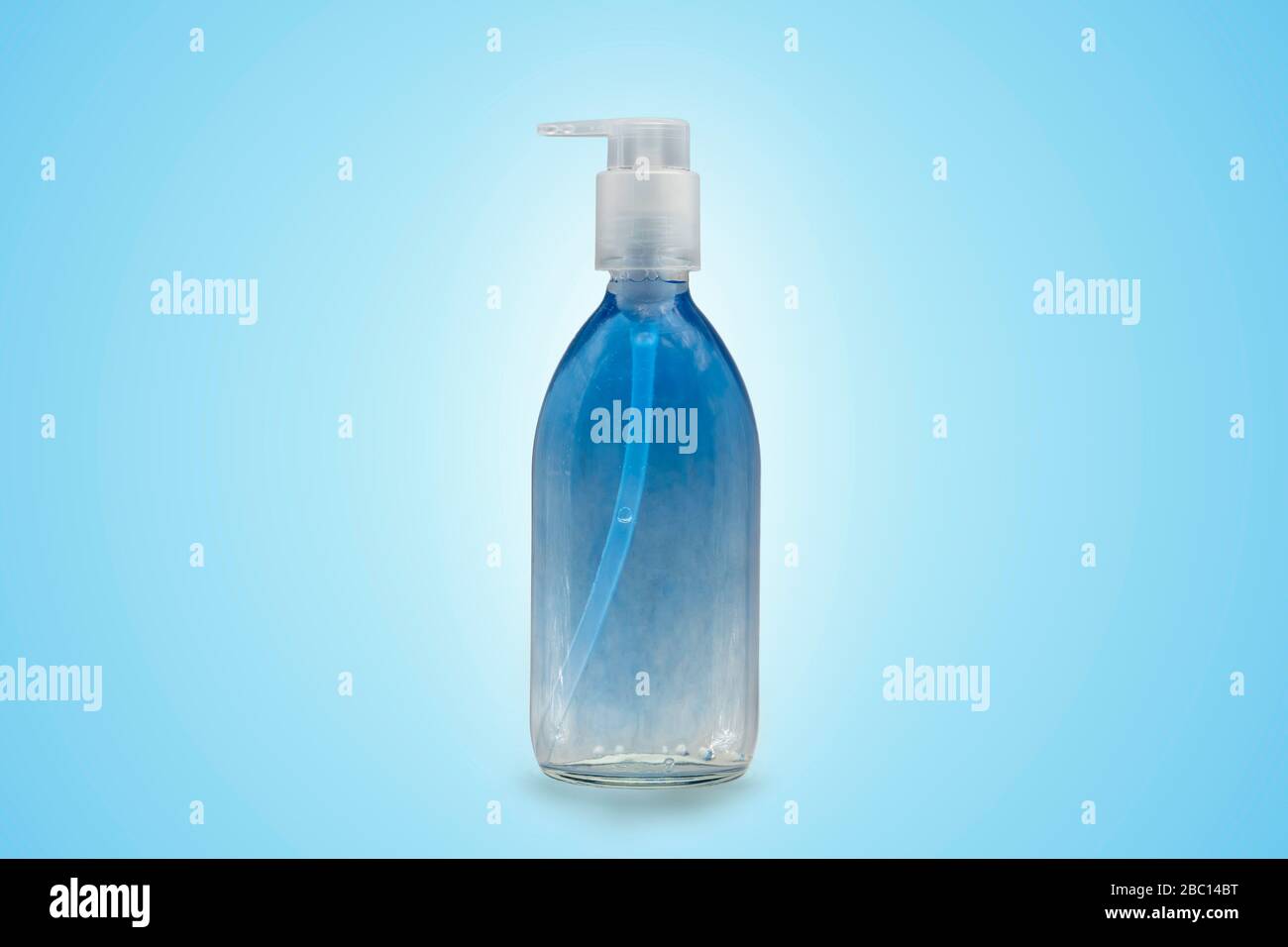 Sapone blu e trasparente in flacone di vetro con pompa per uso cosmetico, igienico o medico. Sfondo con spazio di copia. Foto Stock