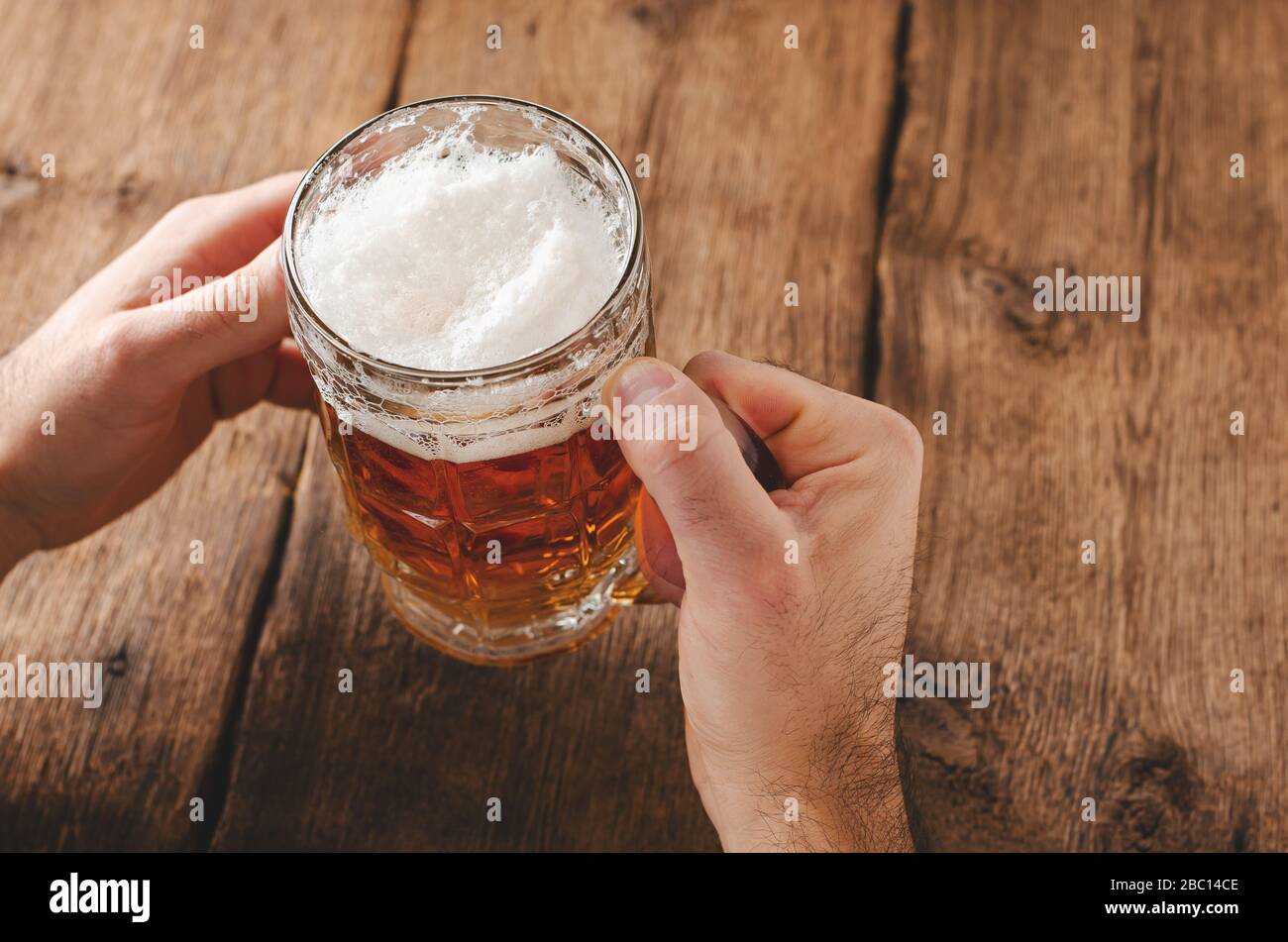 Maschio di mani bicchiere pieno di birra bionda. Leasure concetto. Spazio di copia Foto Stock