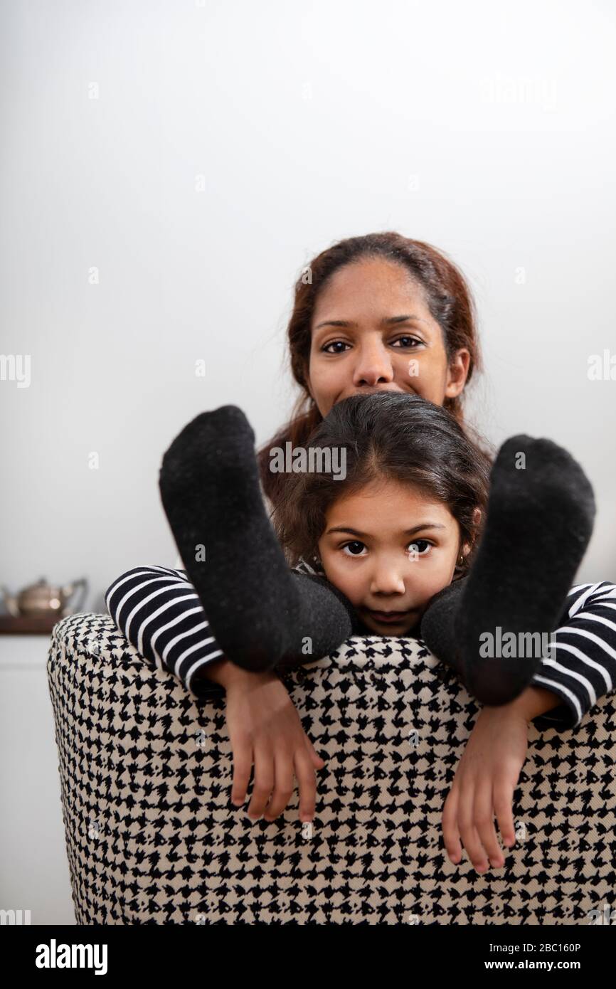 Ritratto di madre felice e di sua figlia insieme su poltrona Foto Stock
