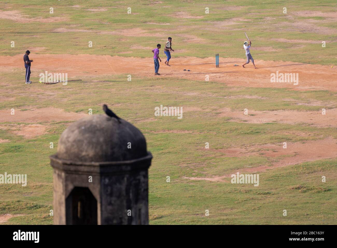 La gente del posto gioca un gioco sociale di campo Samanala arte di cricket, Galle, Sri Lanka Foto Stock