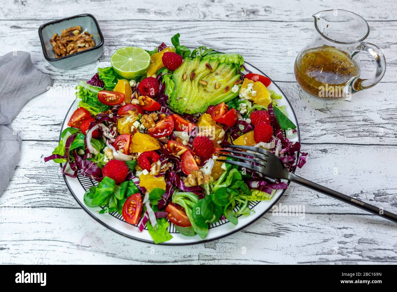 Piatto di insalata mista colorata con formaggio feta, barbabietola comune, noci, pinoli, lamponi, arance e insalata di mais Foto Stock