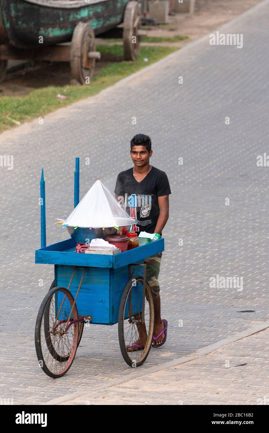 Giovane uomo che sfreccia un carrello di strada su Rampart Street, Galle, Sri Lanka Foto Stock